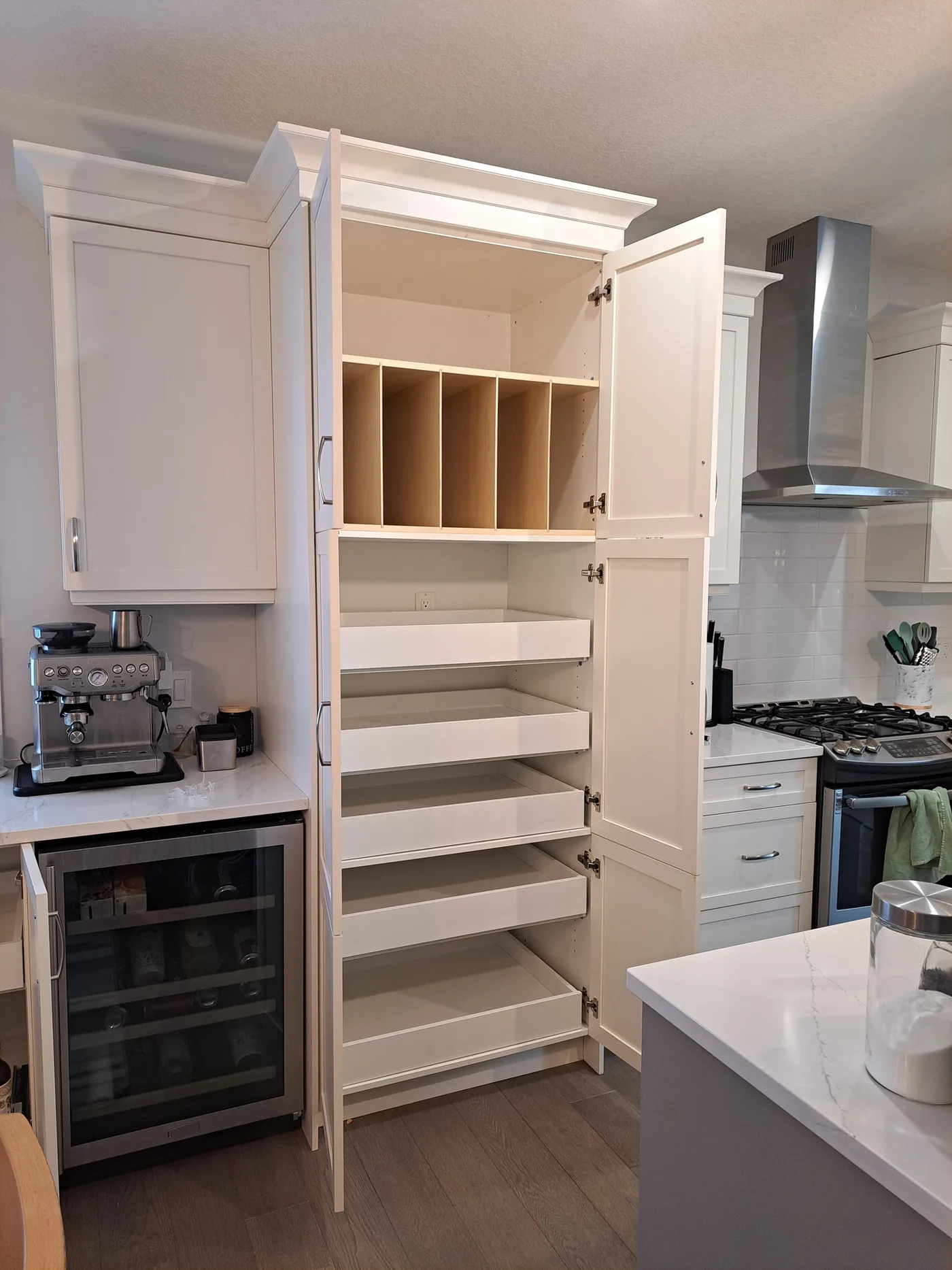White pantry cabinet with vertical dividers and multiple pull-out shelves