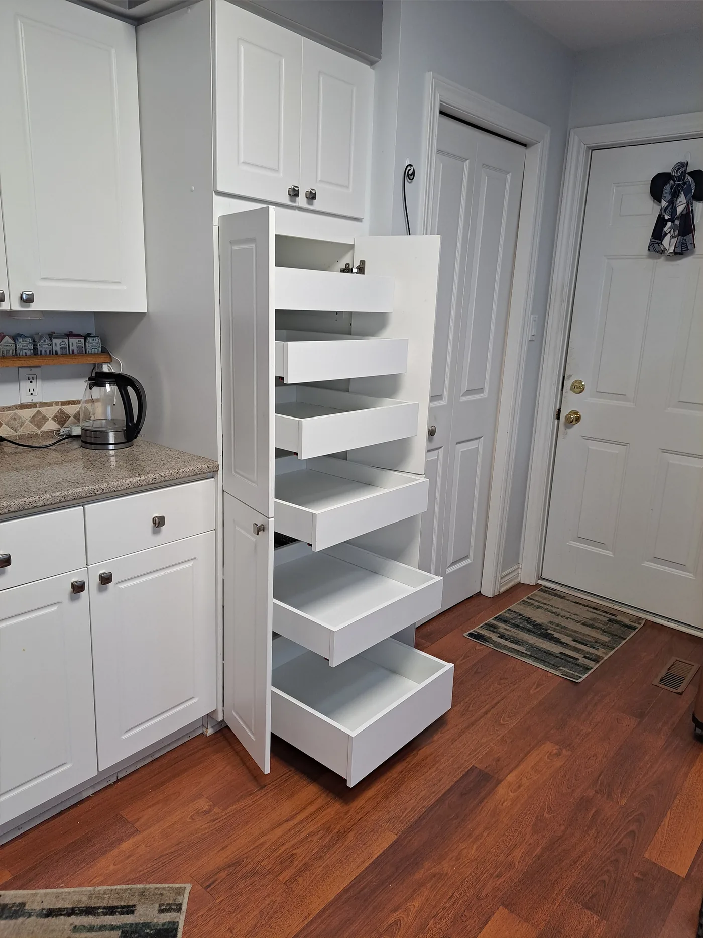 Tall cabinet with six white pull-out drawers extended