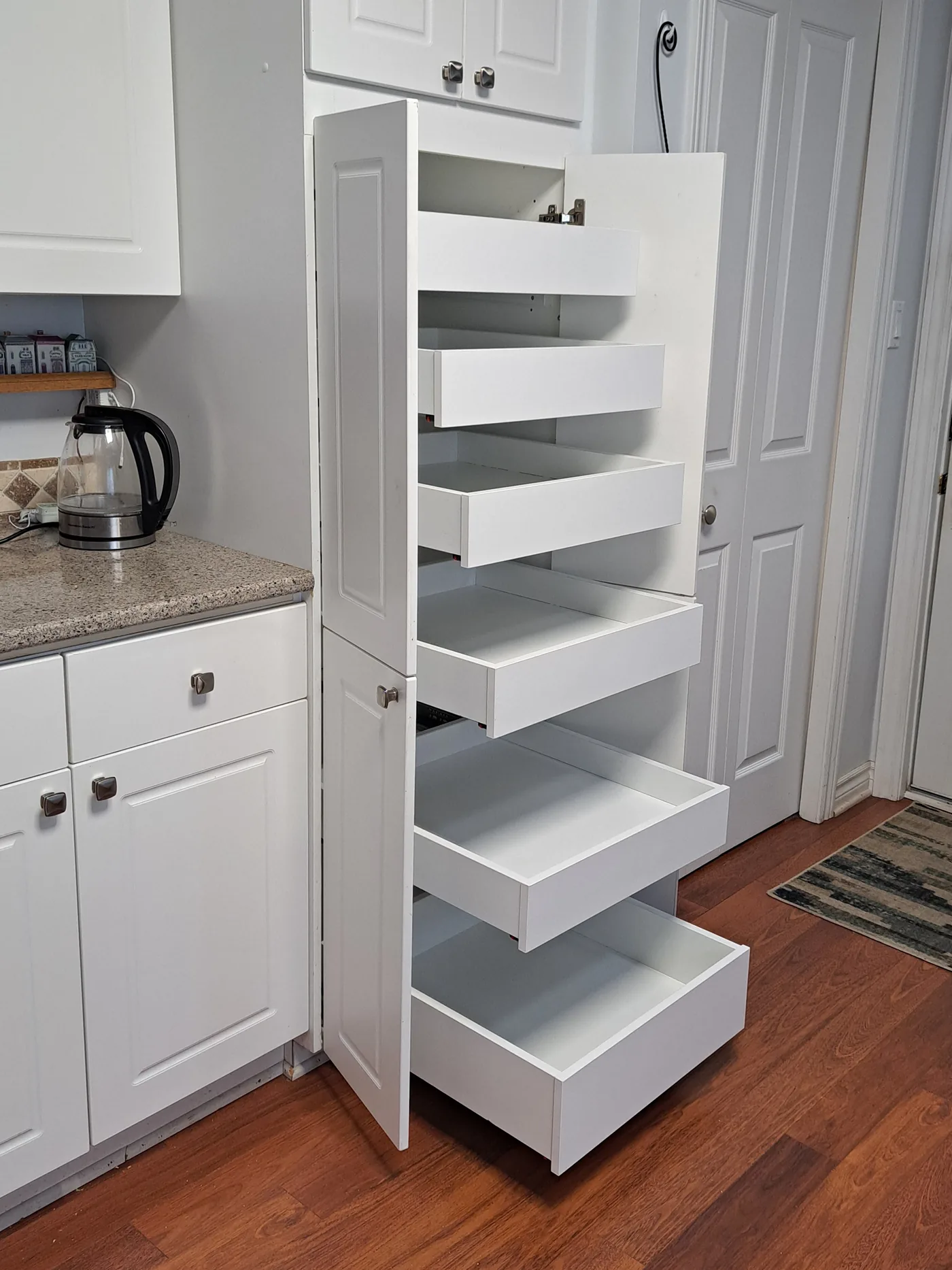 Pull-out shelves staggered open in a white kitchen cabinet