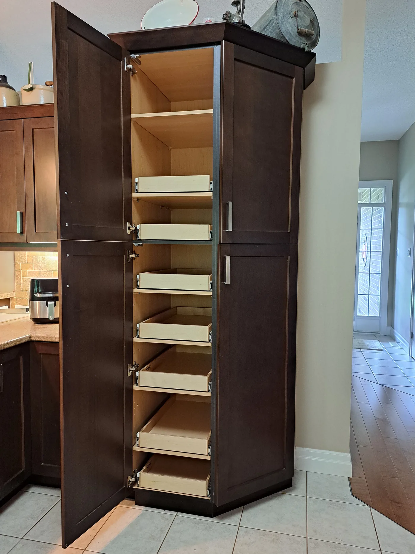 Tall pantry cabinet fitted with white pull-out shelves at varying heights