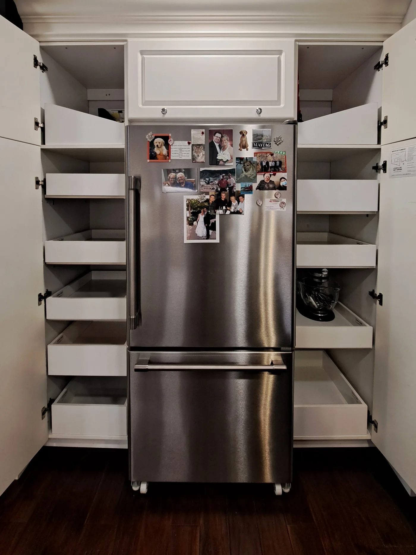 Cabinets on both sides of a refrigerator fitted with pull-out shelving